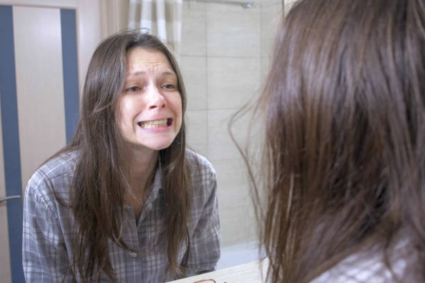 아름다운 갈색 머리 여자는 거울에 그녀의 노란색 이빨을보고 화가 가져옵니다. - brushing teeth healthcare and medicine cleaning distraught 뉴스 사진 이미지