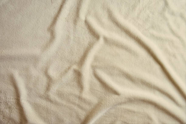 istock Fluffy gentle pastel biege fabric with waves and folds. Soft pastel textile texture. 1329987263