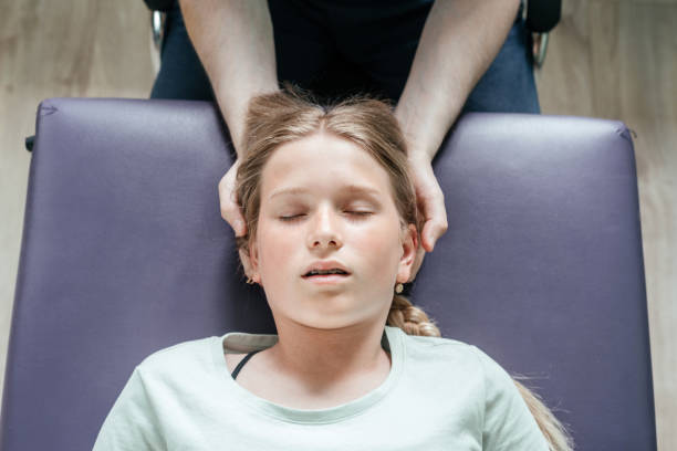 tratamento osteopético de uma paciente com técnica prática suave cst, alívio da tensão do sistema nervoso central - head massage headache massaging alternative therapy - fotografias e filmes do acervo