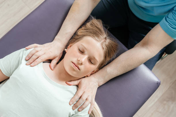 leczenie ostheopatyczne dziewczynki za pomocą cst delikatnej techniki hands-on, napięcie ośrodkowego układu nerwowego łagodzi - head massage headache massaging alternative therapy zdjęcia i obrazy z banku zdjęć