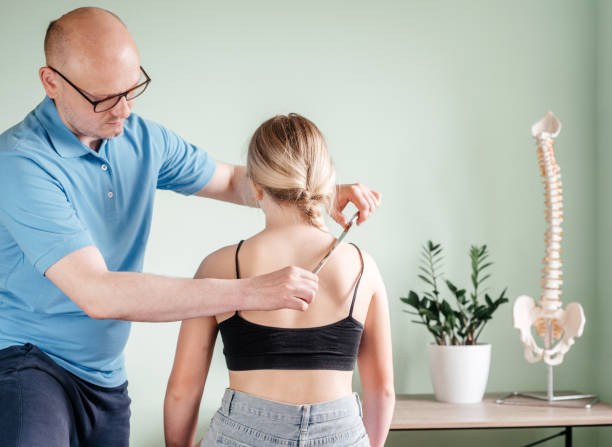 istock Osteopath practitioner performing fascia release maniupulations using IASTM treatment, girl receiving soft tissue treatment on her neck with stainless steel tool 1329989162
