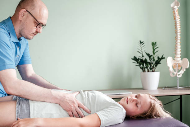 istock Osteopath practitioner releasing the diaphragm of a female patient, rib cage release massage, breathing muscle relaxation 1329989198