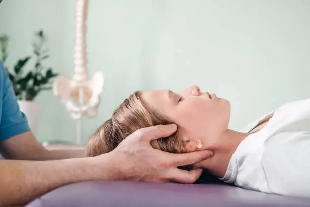 Photo of A girl receiving CST treatment. Osteopathic Manipulation and CranioSacral Therapy for children and adults