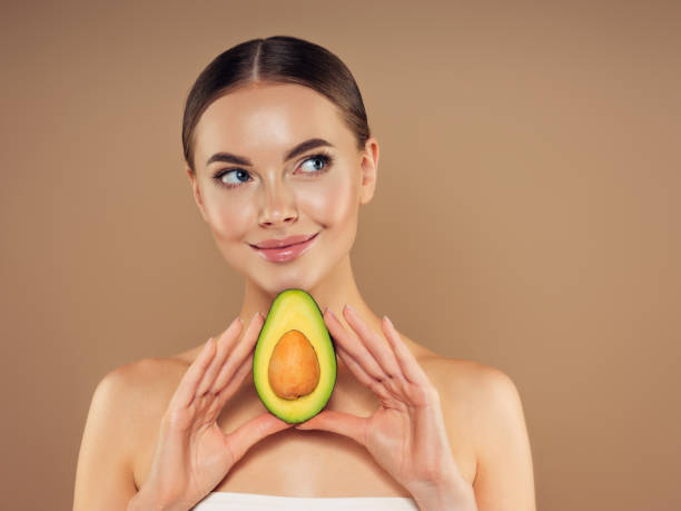 istock Beautiful girl with avocado 1329990034