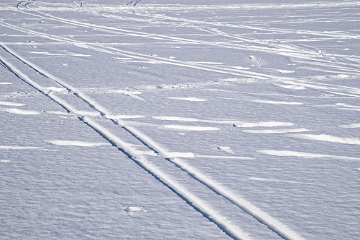 Ski track on flat snow surface. Winter season skiing. Winter sport background.