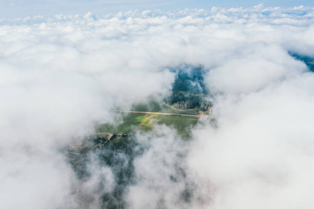 High flight in the cumulus clouds over agricultural fields in summer. Higher than clouds