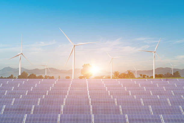 istock Solar panels with wind turbines against blue sky background 1329990942