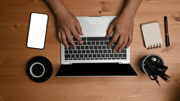 istock Above view man hands typing on keyboard of laptop computer. 1329993075
