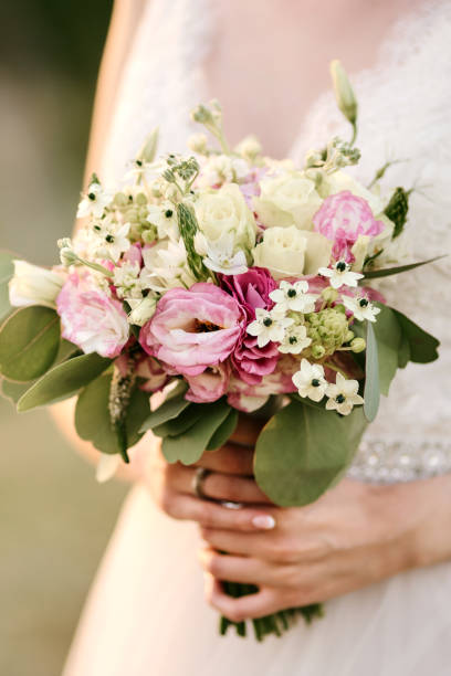 istock Bride holding her bouquet with flowers 1329993404