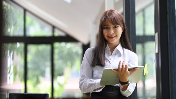 istock Smiling young college student holding digital tablet and looking at camera. 1329994057