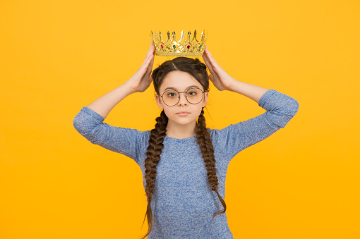 Admiration is the reward. Little beauty queen yellow background. Small child got crown as reward. Jewellery reward. Reward and recognition. Proud champion. Success and triumph.