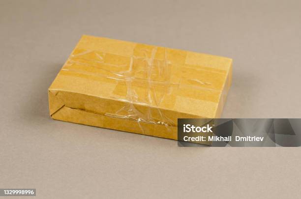 Brown Cardboard Box On Gray Background Closed Postal Package Wr Stock Photo - Download Image Now