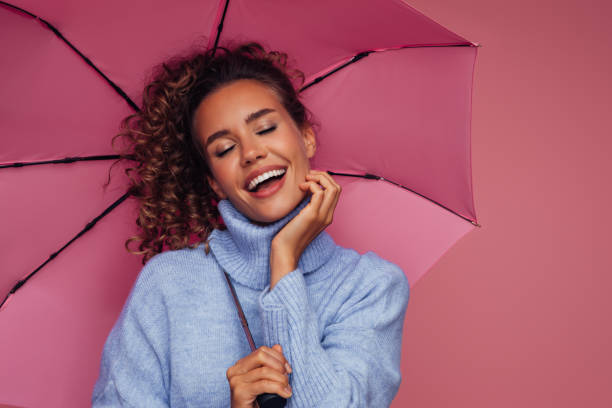 istock Girl holding pink umbrella 1330000355