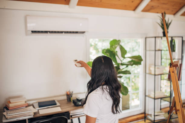 Woman turning on air conditioner