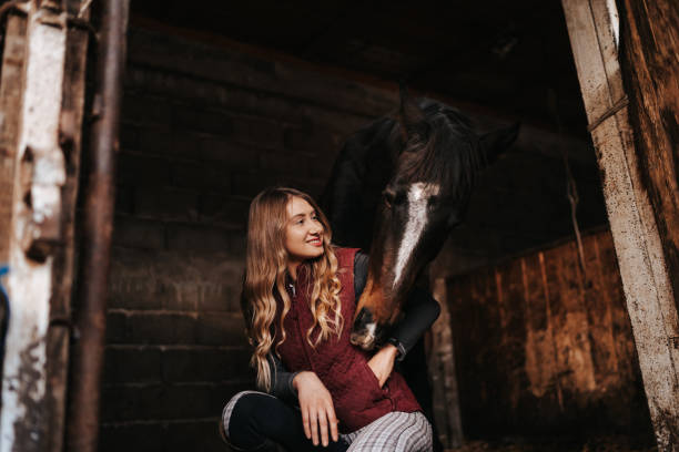 istock Young woman bonding with her horse in stable 1330003833