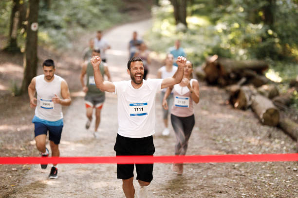 istock Successful marathon runner crossing finish line with arms raised. 1330003877