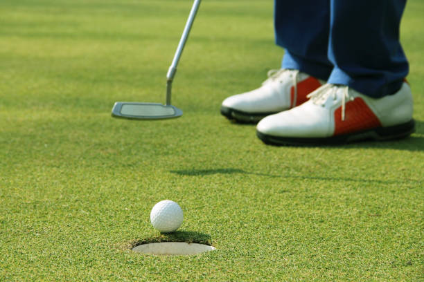 istock Golfer putting golf ball on the green golf. 1330004008