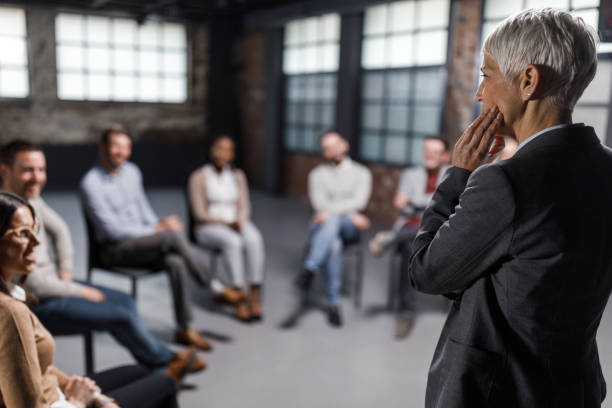 istock Profile view of a psychologist talking on a group therapy. 1330005312