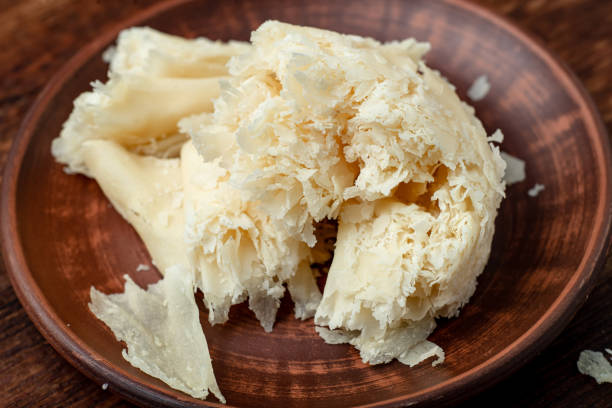 istock Hard cheese sliced chips on a clay plate on a wooden background. 1330005647