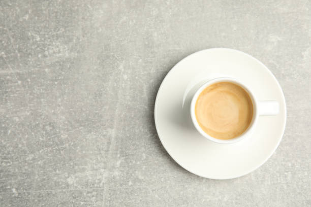 istock Cup of hot aromatic espresso on light table, top view. Space for text 1330006395