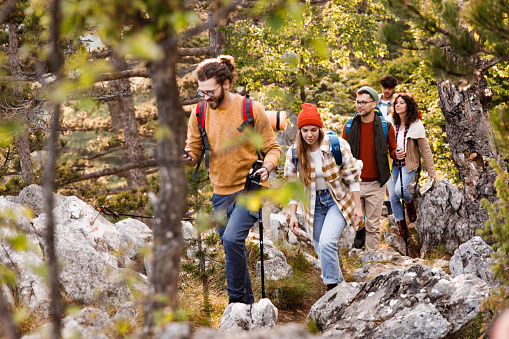 Group of young hikers walking through rocky nature.