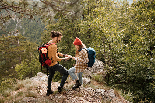 Happy couple of backpackers enjoying during their adventure on a mountain.