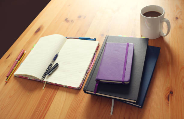 istock tidy workspace background to study or work at home - open blank notebook with pens, books and a cup of coffee on a wooden table of a freelance office 1330007218