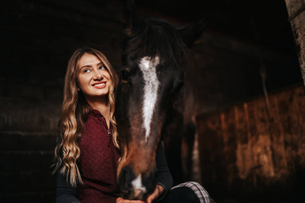 istock Young woman hugging her horse in stable 1330007405