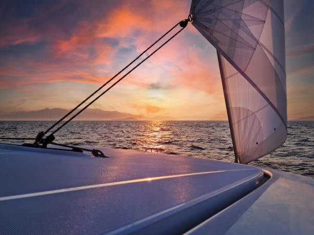 sailing yacht catamaran sea sunset - moody sky water sport passenger craft scenics imagens e fotografias de stock