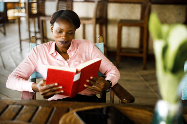 istock Smiling black woman reading a book. 1330009723