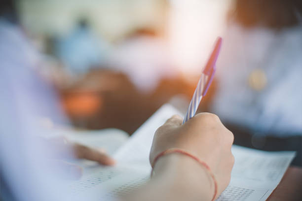 istock Students writing and reading exam answer sheets exercises in classroom of school with stress 1330010776