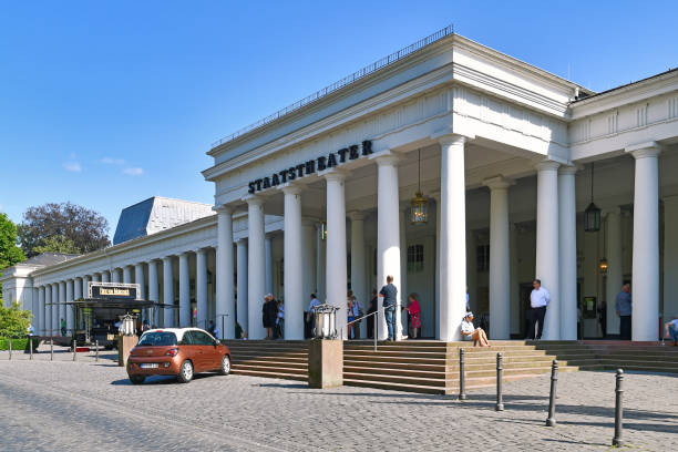 Wiesbaden, Germany - Entrance of state theater called 'Hessisches Staatstheater' with people Wiesbaden, Germany - July 2021: Entrance of state theater called 'Hessisches Staatstheater' with people on sunny day opera stock pictures, royalty-free photos & images