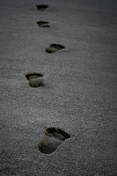 istock Clear human Footprints on the black sand off the coast 1330012230