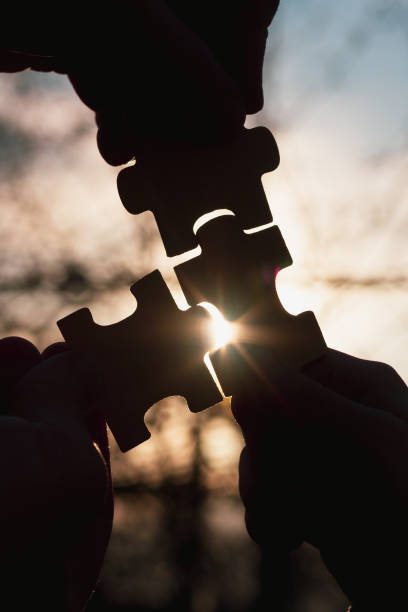 Connect the appropriate puzzles into a whole, silhouettes against the sky stock photo