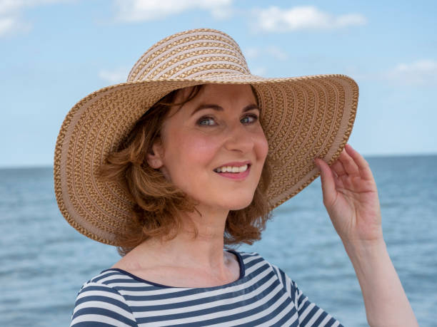 istock Mature woman with beach hat 1330017304