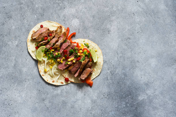 Tacos with beef, pepper and corn with sauce on a concrete background. Traditional Mexican food. stock photo