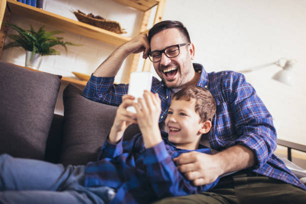 istock Father and son are using smartphones play video game and smiling while spending time together at home 1330019687