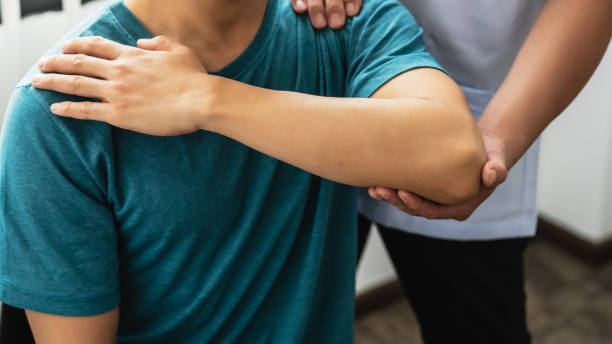 Close-up of a physiotherapist stretching to a man patient at the clinic. Close-up of a physiotherapist stretching to a man patient at the clinic. therapy stock pictures, royalty-free photos & images