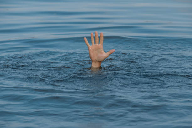 istock Drowning man reaching for help in sea, closeup 1330022013