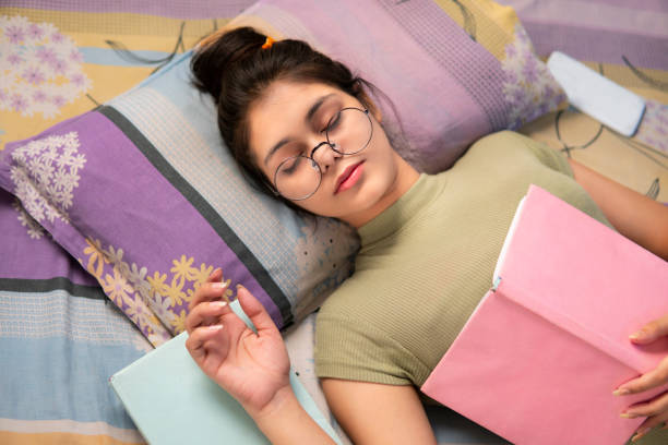 istock Girl student sleeping with a book on her chest while reading it. 1330024316