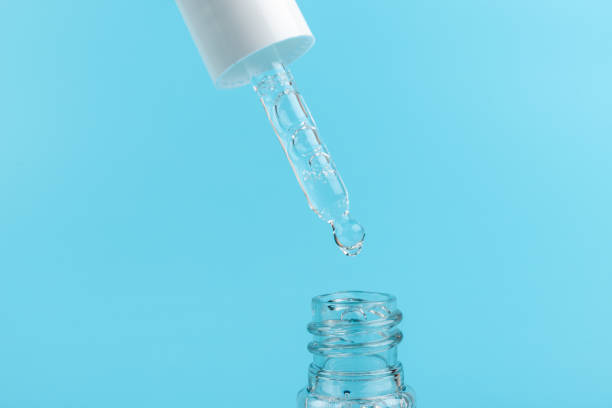 istock face serum drop with bottle on blue background. 1330024427