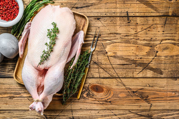istock Raw whole farm duck with herbs. wooden background. Top view. Space for text 1330024771