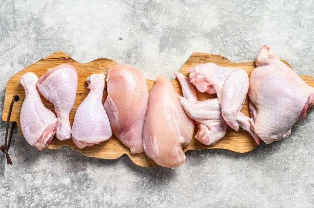 istock Raw uncooked chicken meat on a cutting board. Gray background. Top view 1330024821