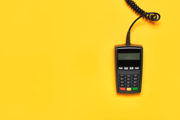 istock POS payment terminal on yellow background. Minimal financial service flat lay, copy space 1330024907