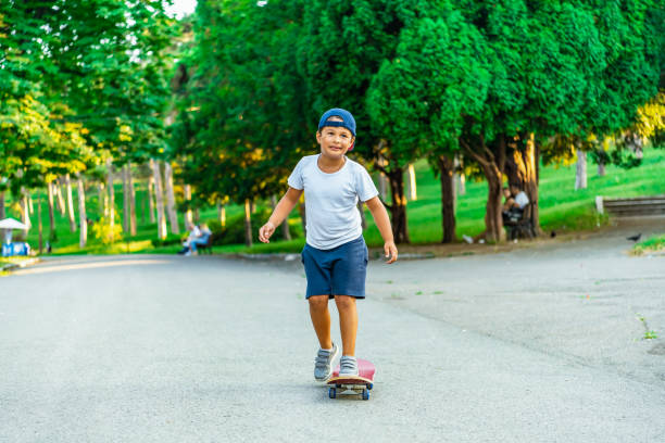 istock Little boy is riding a skateboard in the park 1330024948