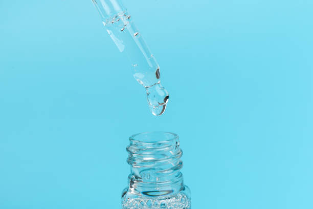 istock face serum drop with bottle on blue background. 1330024956