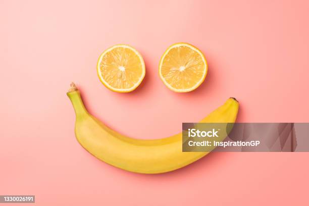 Top View Photo Of Smiling Face Made From Two Lemon Halves And Banana On Isolated Pastel Pink Background Stock Photo - Download Image Now