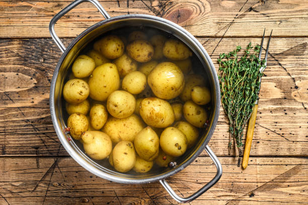 Boiled baby Potatoes in a saucepan. Wooden background. Top view Boiled baby Potatoes in a saucepan. Wooden background. Top view. prepared potato stock pictures, royalty-free photos & images