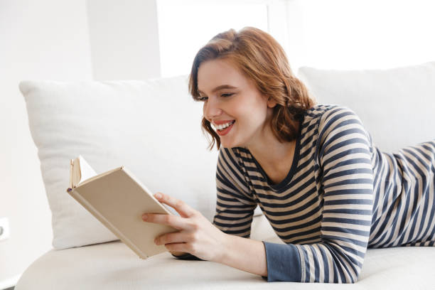 istock Beautiful smiling young woman relaxing on a couch 1330029061