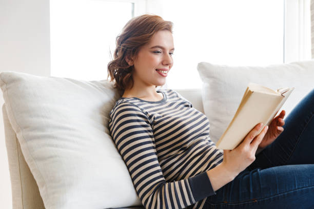 istock Beautiful smiling young woman relaxing on a couch 1330029303